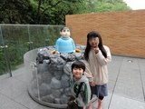 藤子・F・不二雄ミュージアム、きこりの泉のきれいなジャイアンの前で記念写真するnneとknk